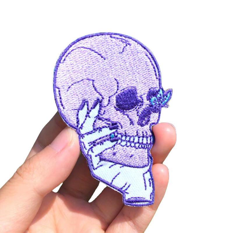 Unisex pink skull patch in hand, perfect gothic accessory for stylish clothing decoration.