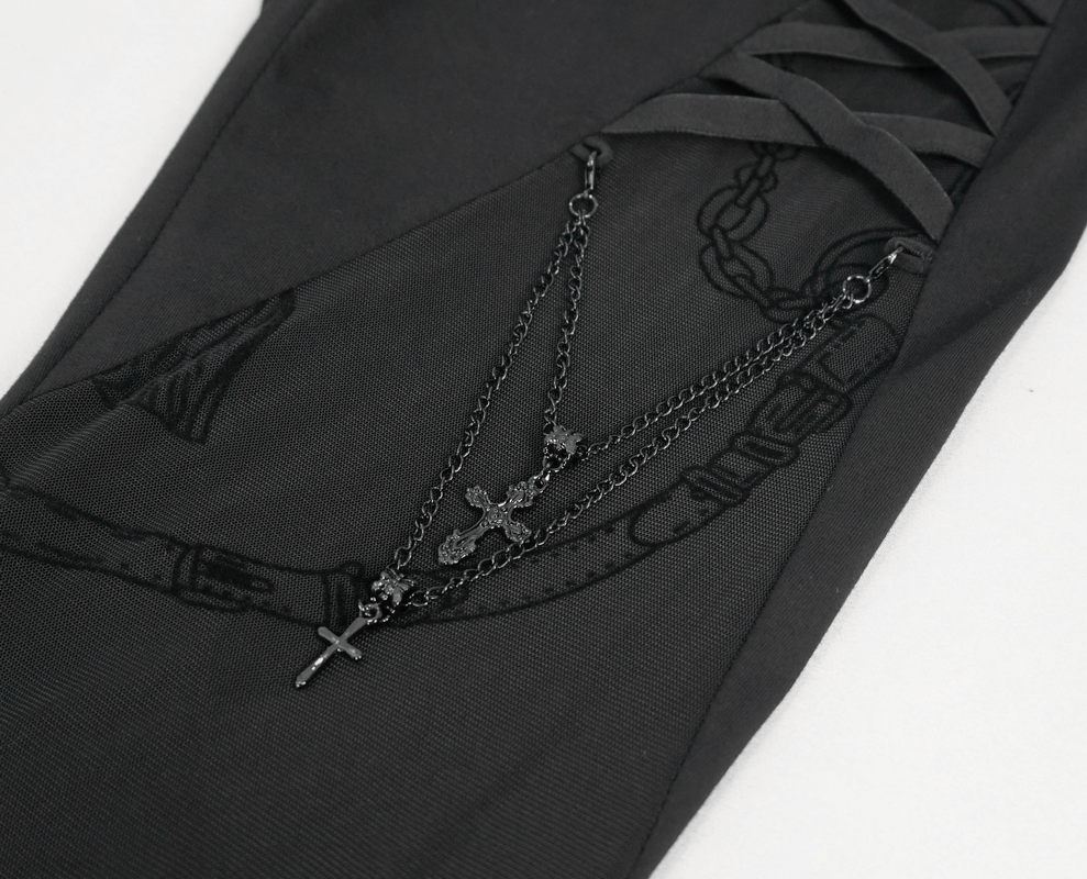 Close-up of gothic patterned semi-transparent leggings featuring cross pendant chains, stylish black skinny pants for women.