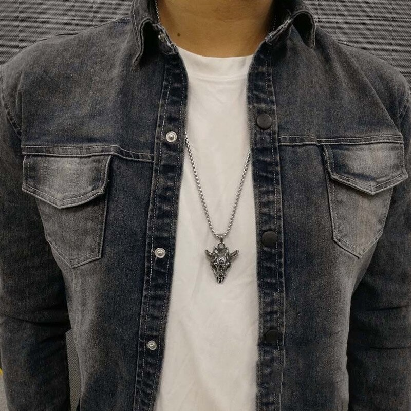 Stylish man wearing a gothic pendant in the form of a sheep skull with a silver chain, showcasing punk biker jewelry.