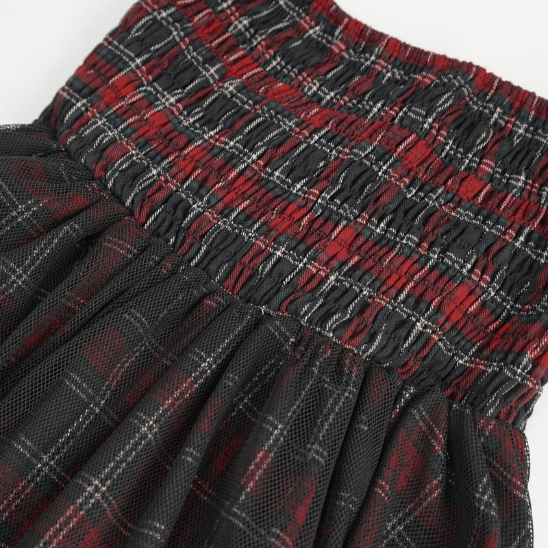 Detail of gothic plaid dress with ruffled lace hemline, showcasing the black and red checked pattern and smocked bodice.