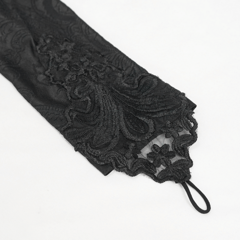 Close-up of floral embroidered lace detail on black gothic dress sleeve.