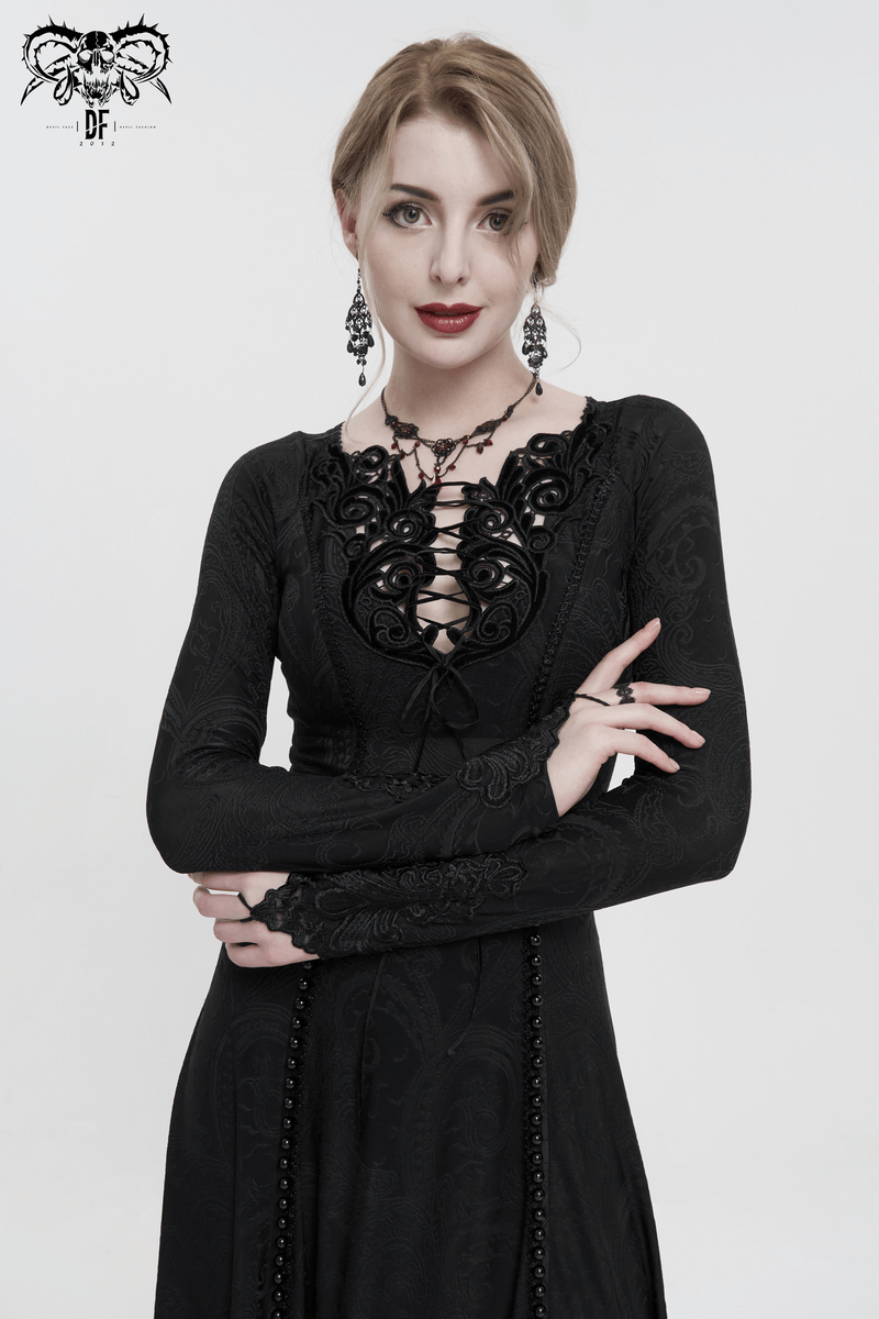 Elegant woman in a gothic black floral embroidered dress with a plunging neckline and long sleeves.