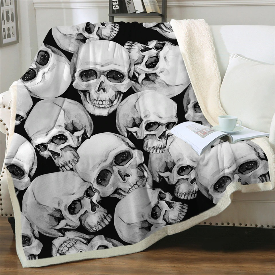 Gothic plush blanket with skull print on black background, cozy and stylish for bed or sofa.
