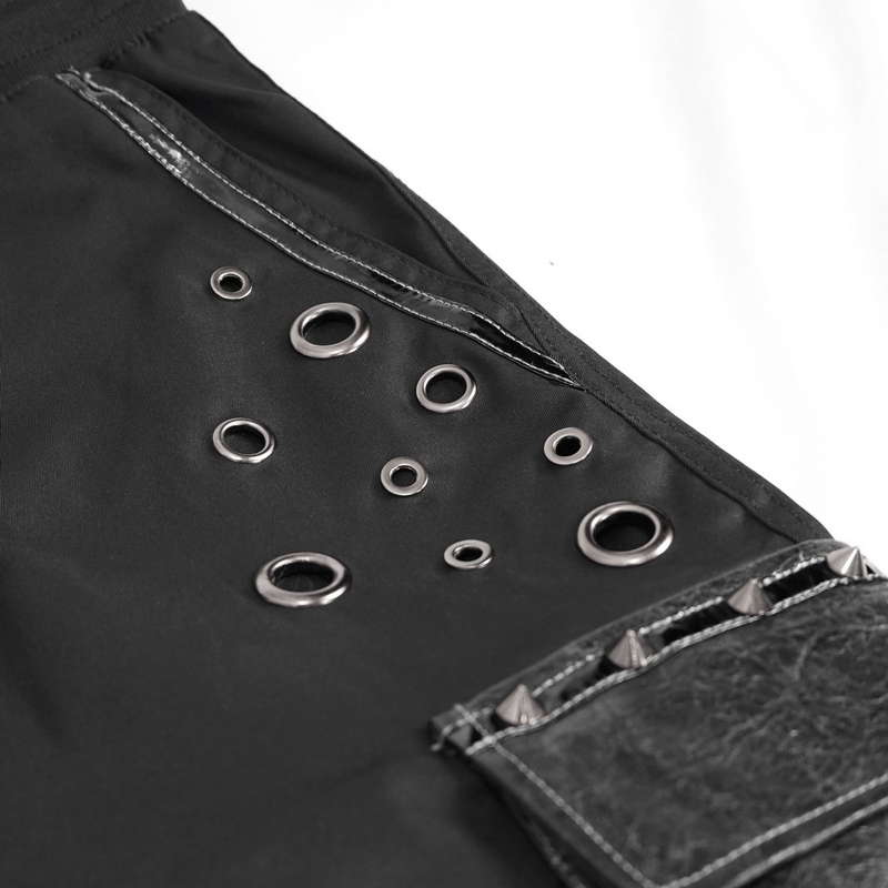 Close-up of black jogger pants featuring grommets and studs, showcasing punk style and big pockets.