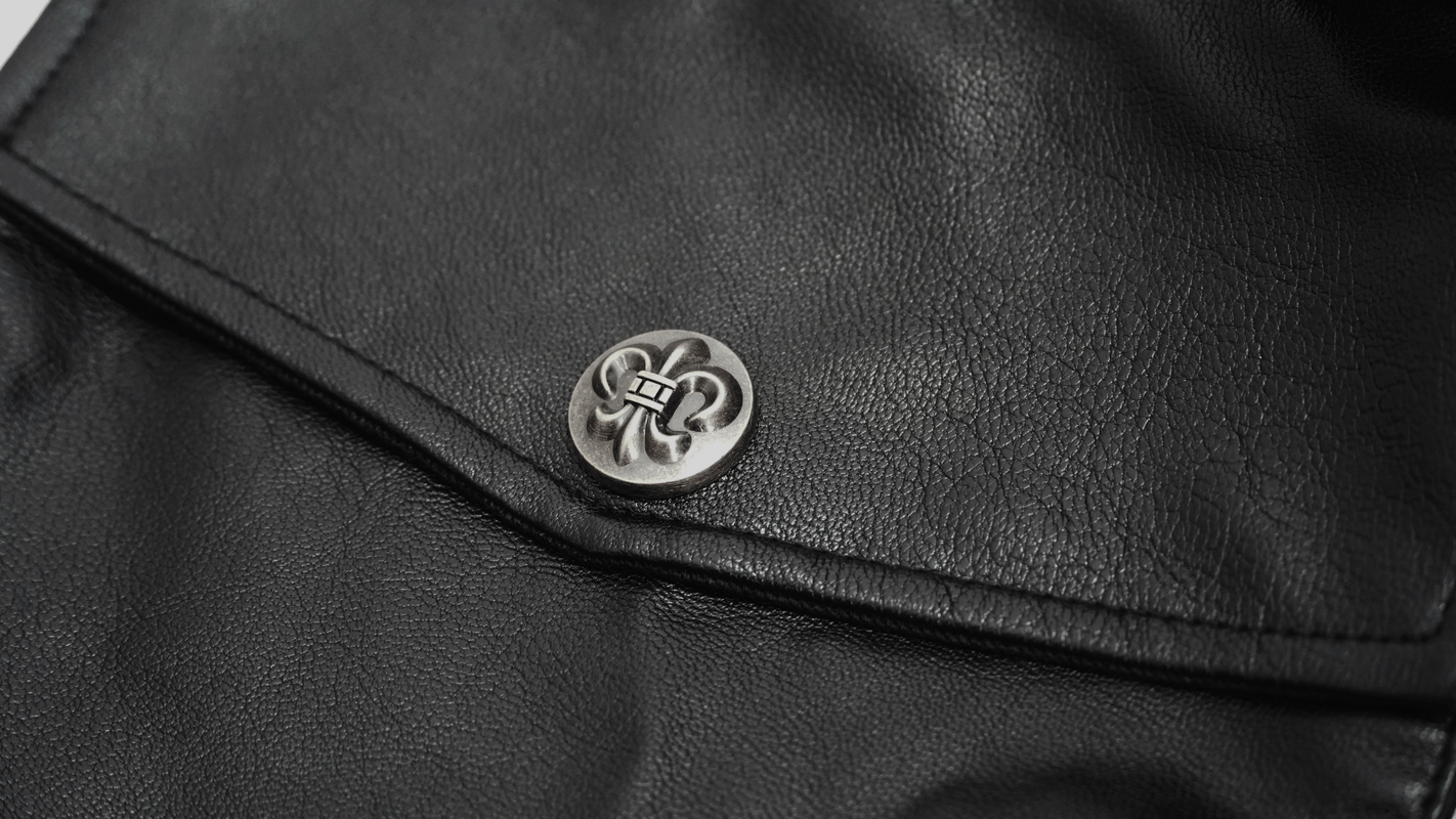 Close-up of a stylish silver button on a men's gothic punk black trench coat showcasing fashion accents.