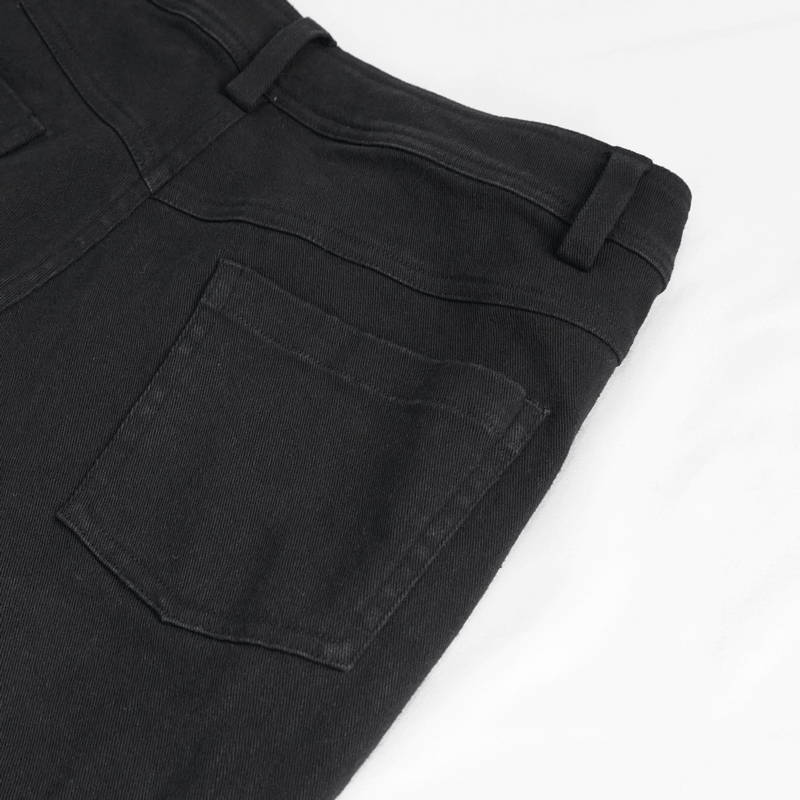 Close-up of Gothic black ripped pants with pockets, perfect for punk fashion style, showing rugged design and modern cut.