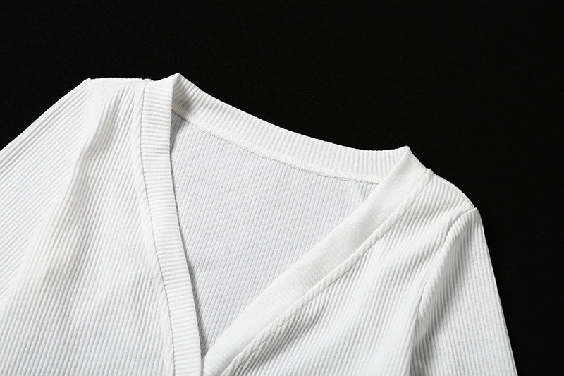 Close-up of a white ribbed v-neck top showcasing the elegant neckline and soft fabric texture.