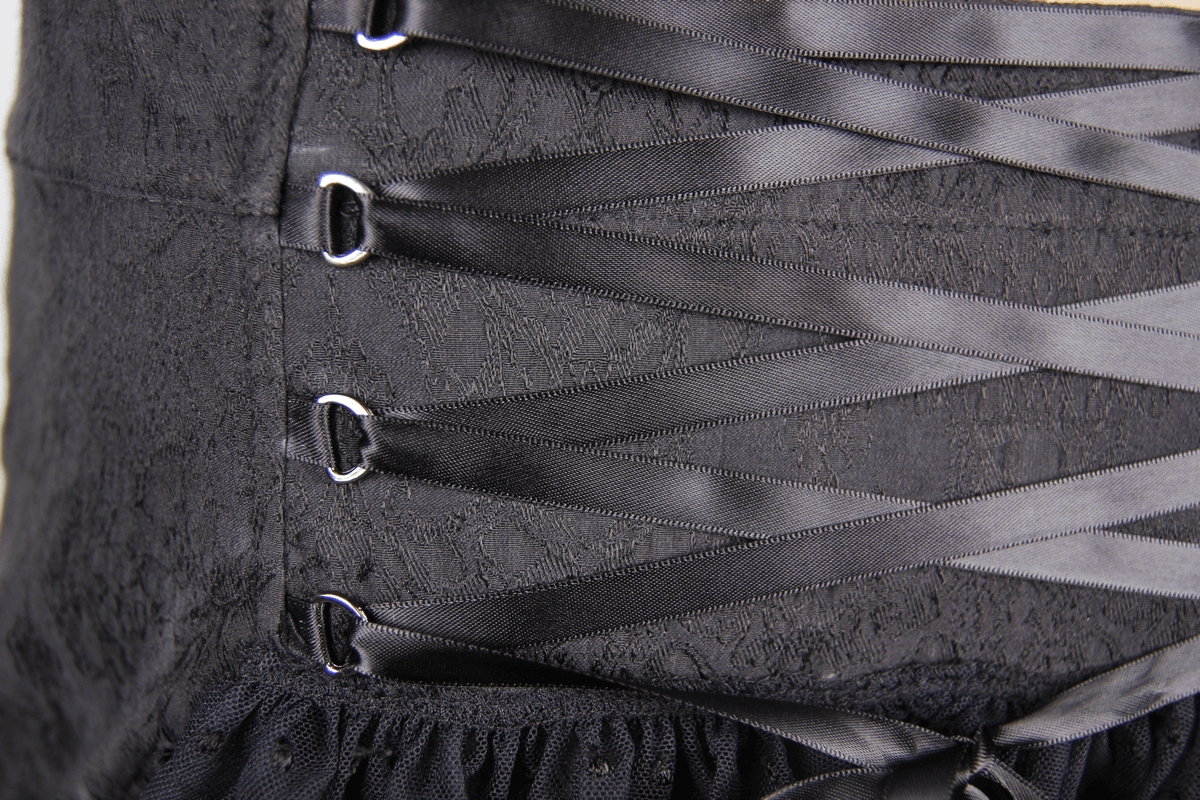 Close-up of gothic short skirt with black lace and ribbon detailing, showcasing stylish ruffles and elegant design.