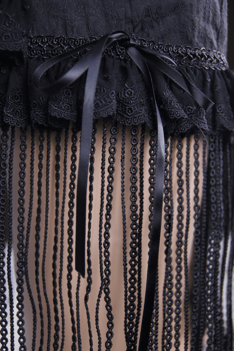 Close-up of gothic short skirt with lace tassels, ruffles, and elegant black detailing.