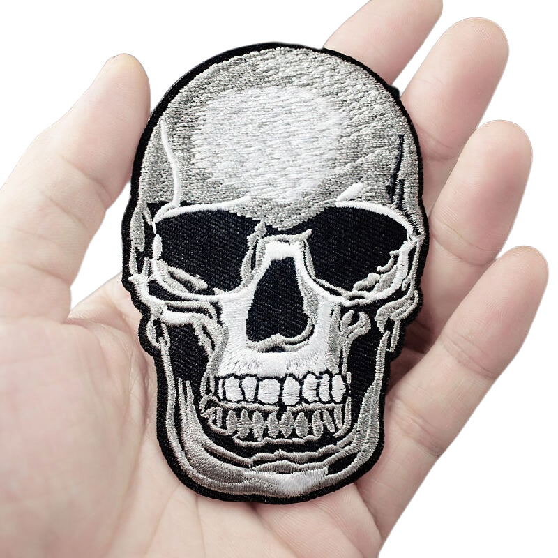 Gothic skull patch held in hand, unisex rock style accessory for jackets and clothing, quality embroidered design.