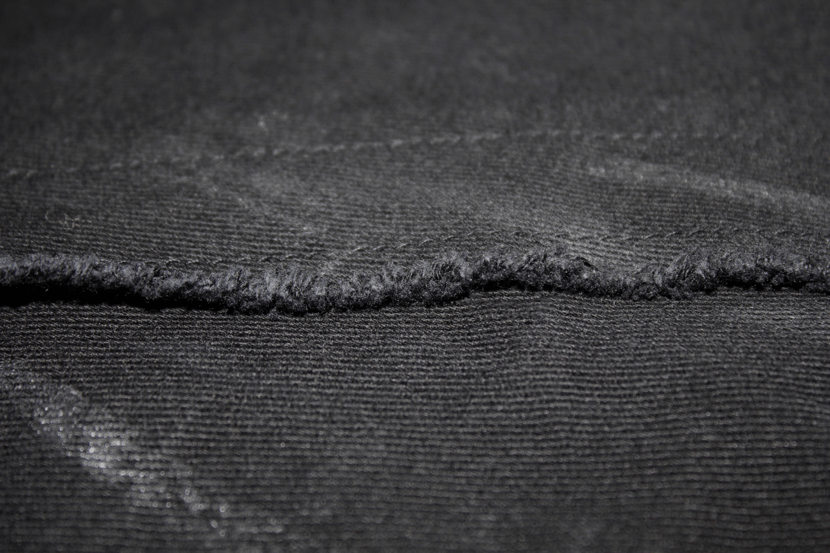 Close-up of black fabric showing texture and stitching details of Gothic slim fit pants.