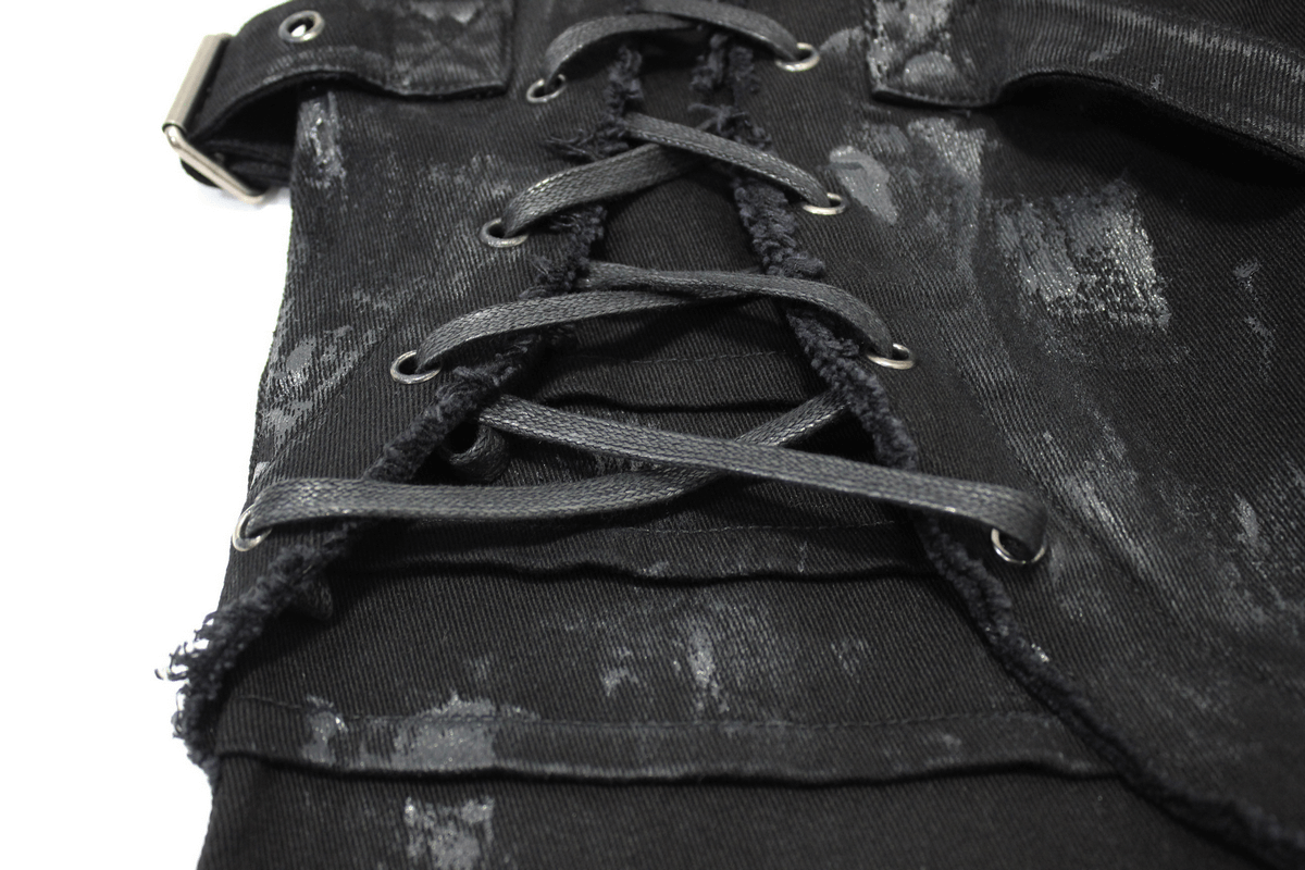 Close-up of gothic slim fit black pants with lace-up detail on the right leg and stylish belt buckle.