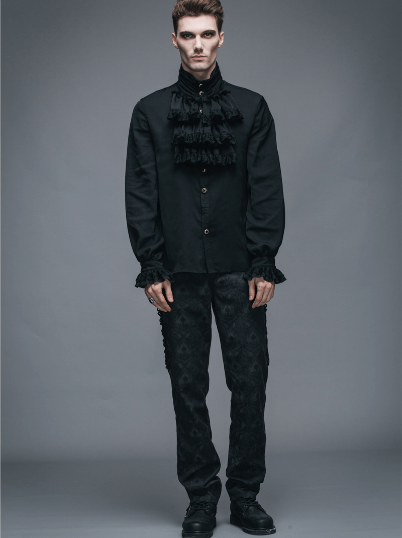 Gothic steampunk male model in a vintage black flounce tie shirt and matching dark trousers.