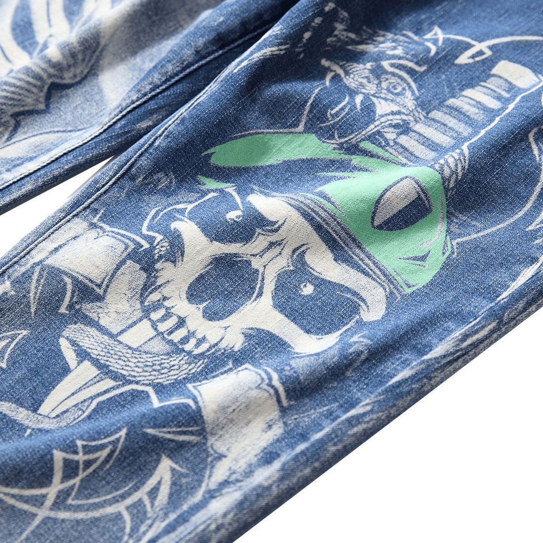 Close-up of Gothic 3D printed denim pants featuring bold skull and graphic design on blue fabric.
