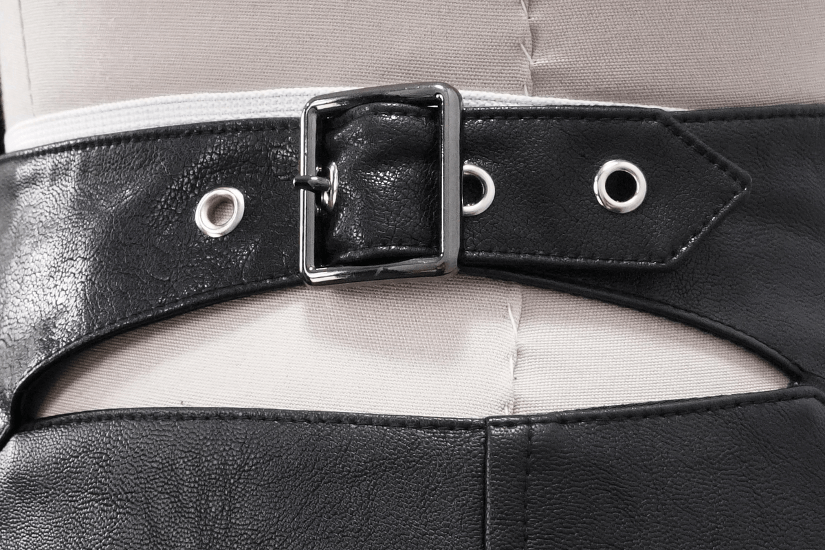 Close-up of a black faux leather belt with a silver buckle and eyelets, perfect for punk and alternative fashion.