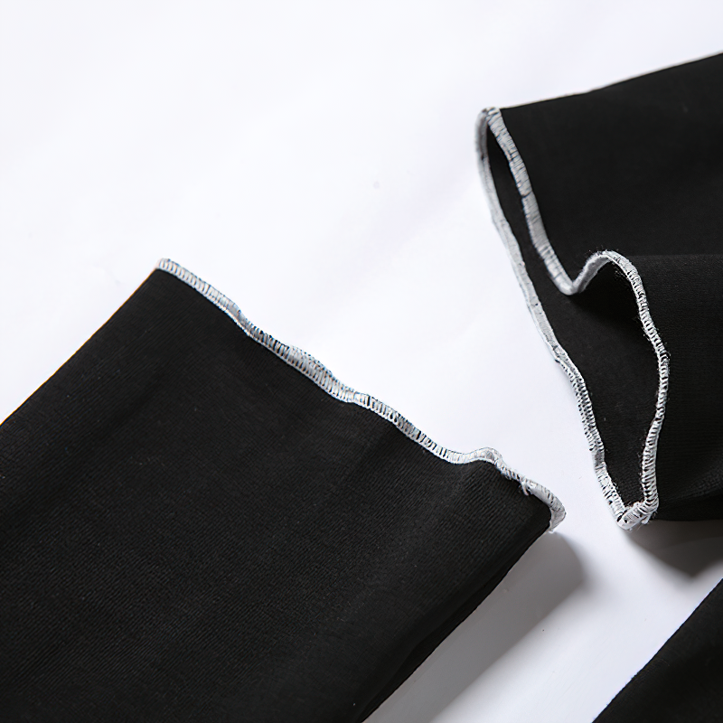 Close-up of black fabric with silver stitching on the edges, showcasing the gothic crop top's hollow out sleeve design.