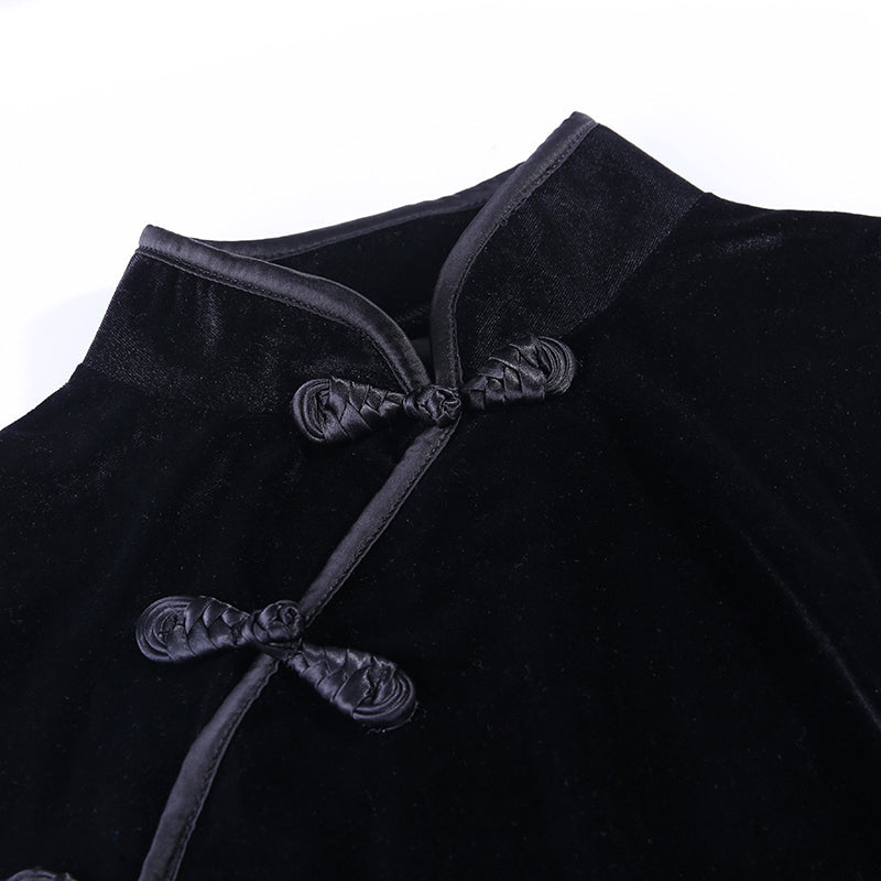 Gothic velvet dress close-up featuring a mandarin collar and decorative knots in elegant black fabric.