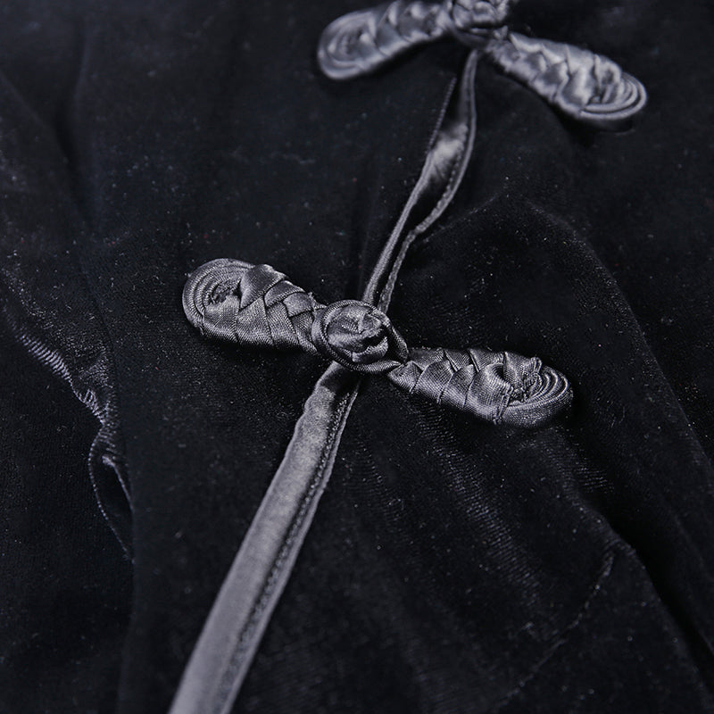 Close-up of gothic style velvet dress details, featuring elegant black knots and luxurious texture.