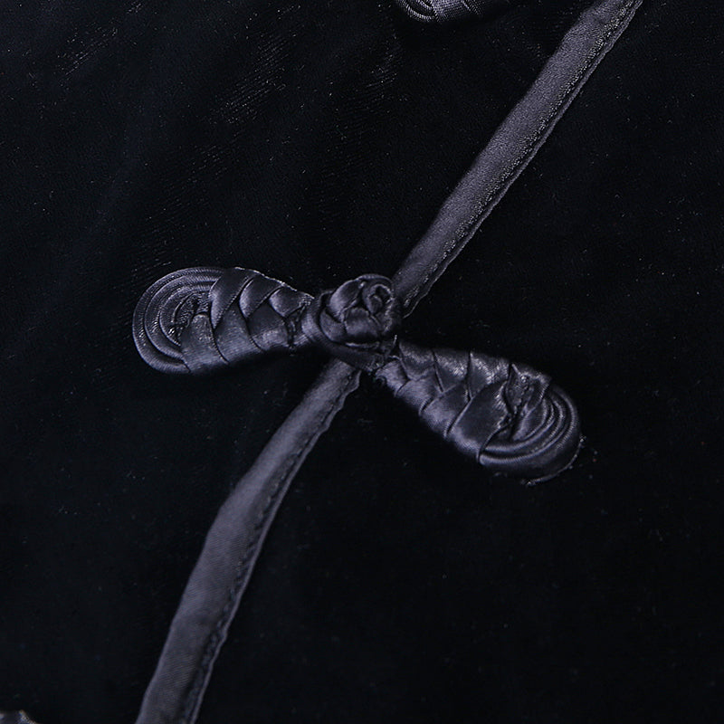 Close-up of elegant black velvet fabric with intricate knot details, showcasing gothic style and sophistication.