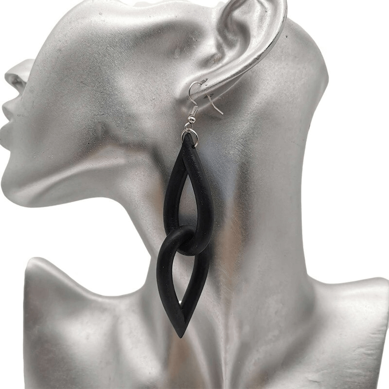 Handmade gothic black rubber earrings dangling from a model's ear, adding stylish flair to any look.