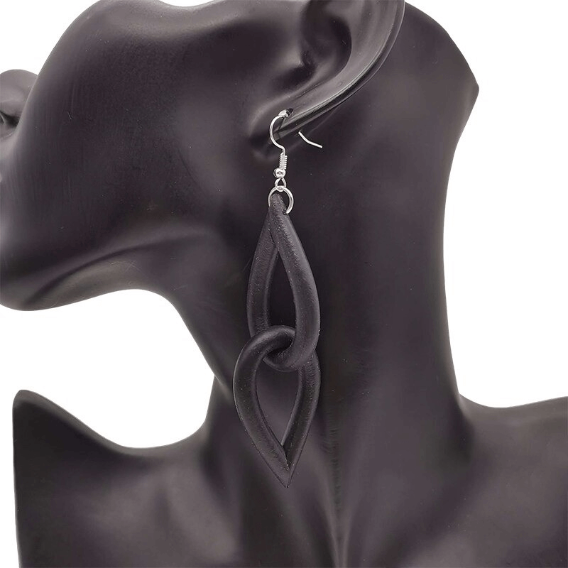 Handmade gothic black rubber earrings showcasing a unique loop design on an elegant display.