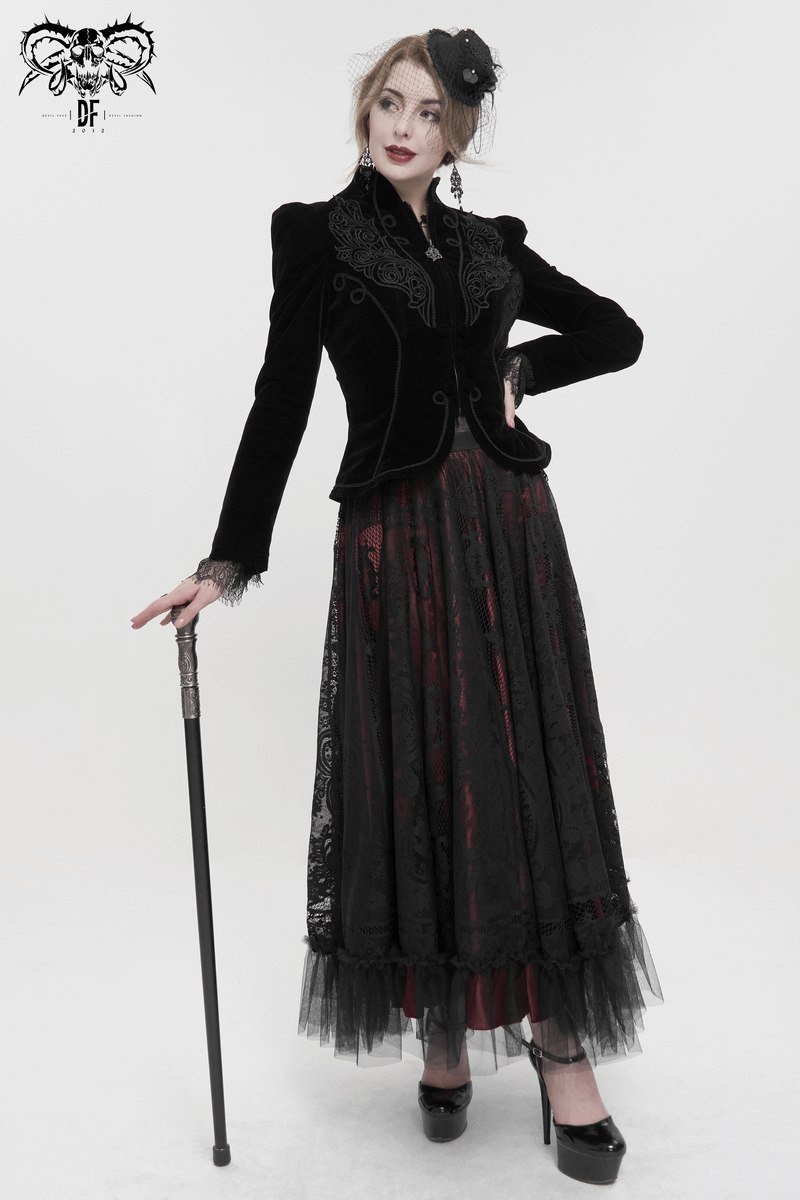 Elegant woman in a gothic black velvet jacket and lace skirt, showcasing vintage style with decorative buttons.