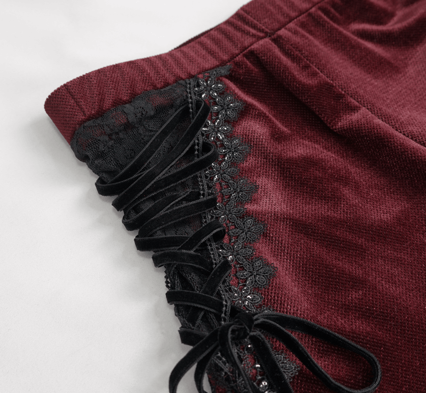 Close-up of wine red flare trousers showcasing lace-up accents and floral lace detailing on the sides.