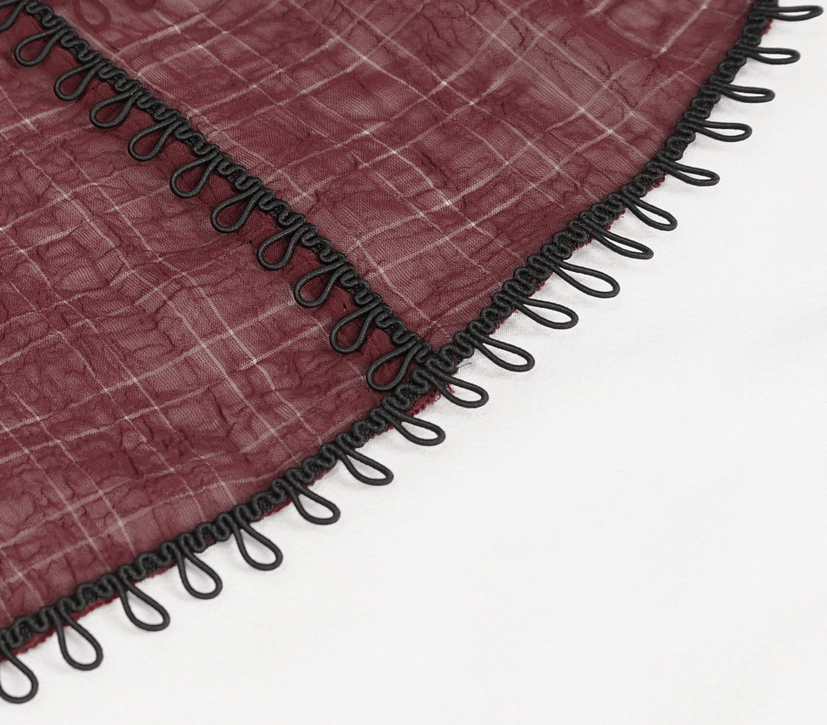 Close-up of wine red fabric with black lace detailing, showcasing gothic style elegance and texture.