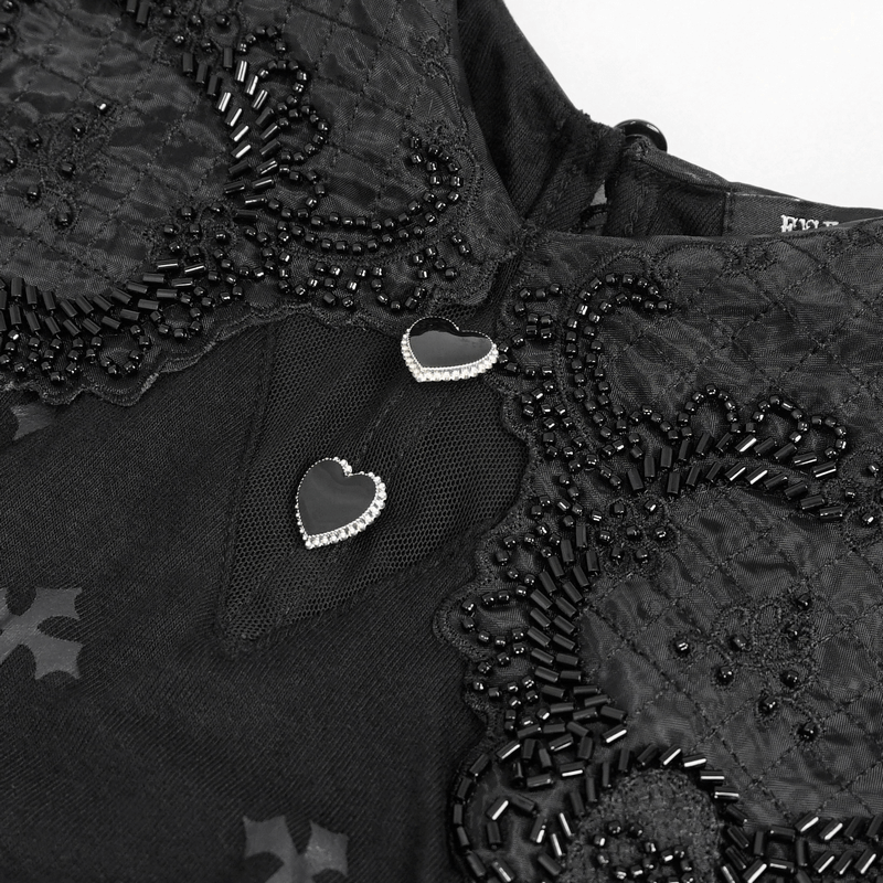 Close-up of gothic dress featuring heart-shaped embellishments and intricate black lace details.
