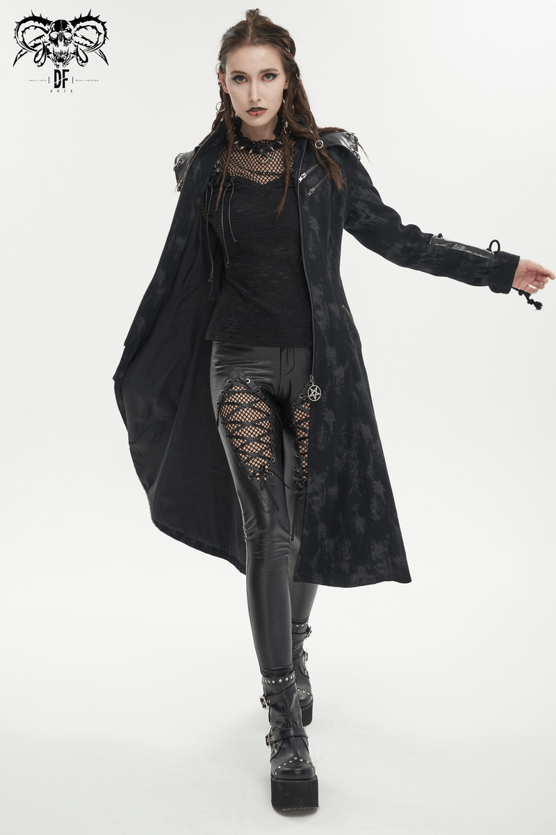 Gothic woman in stylish black coat and PU leather pants with mesh inserts, showcasing a fierce fashion statement.