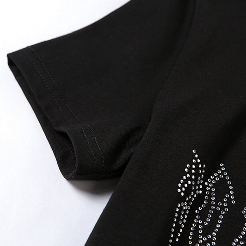 Close-up of gothic black crop top sleeve with shimmering spider sequins detail.
