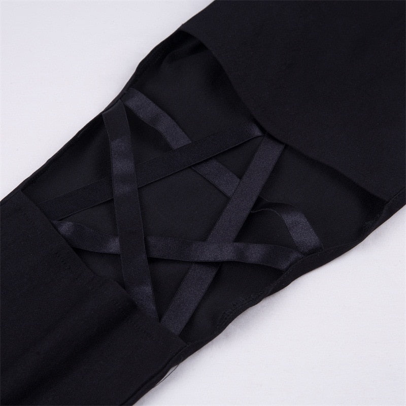 Close-up of gothic pencil leggings featuring pentagram inserts and stylish strap details for a trendy look.