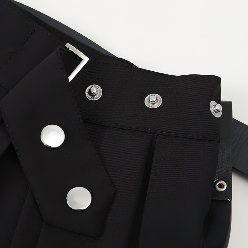Close-up of the stylish buckle and pleats on a Gothic women's black pleated mini skirt with a belt.