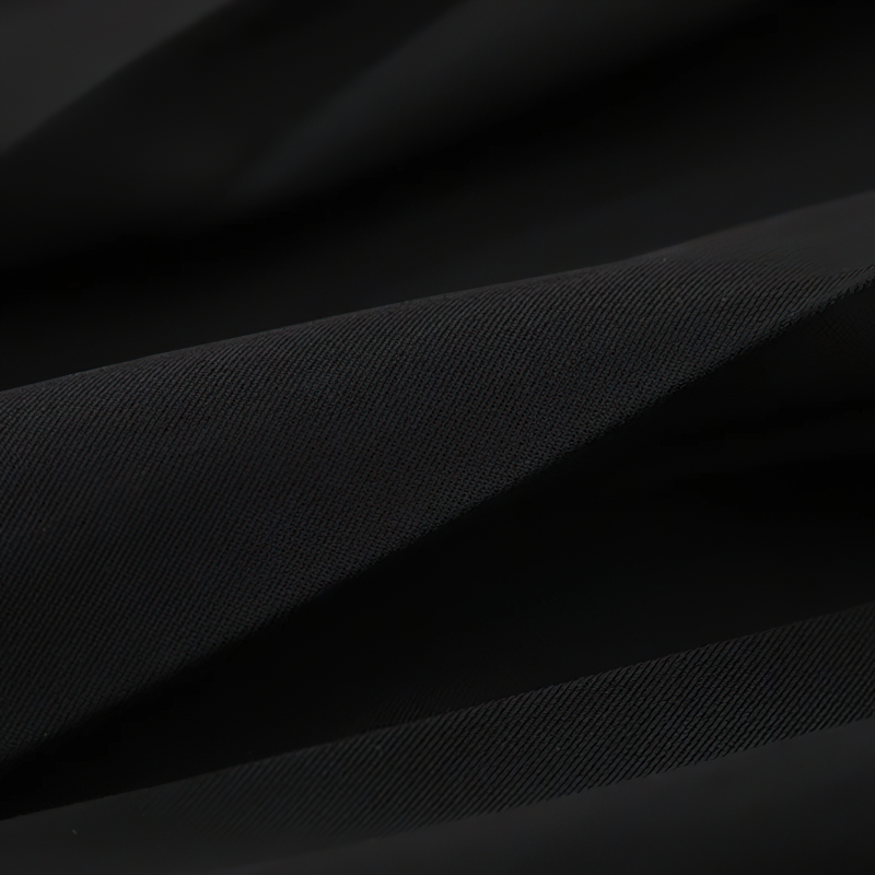 Close-up of soft black fabric, featuring sleek pleats, perfect for gothic fashion items like skirts.