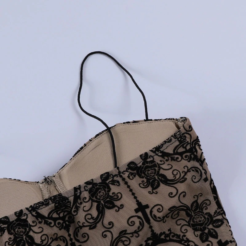 Close-up of a gothic women's top showcasing black floral print and straps, highlighting its elegant vintage design.