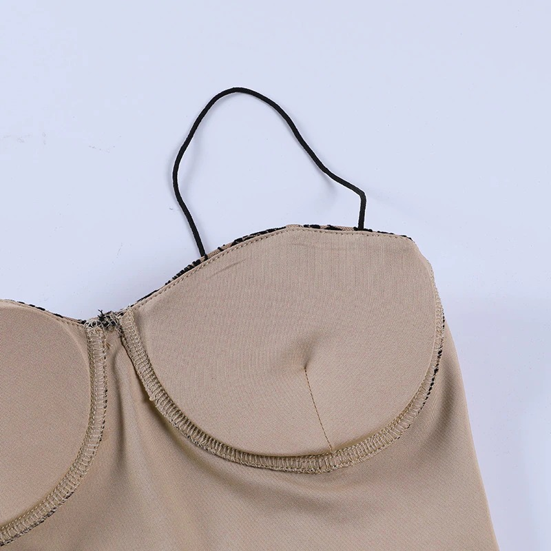 Close-up of a backless gothic women's top in beige with delicate straps and floral print detail, perfect for an elegant style.