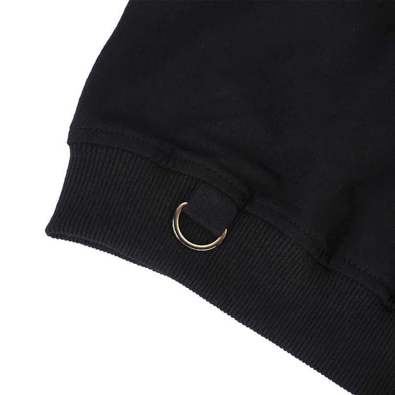 Close-up of black crop top sleeve hem featuring a gold metal ring detail for a stylish gothic look.