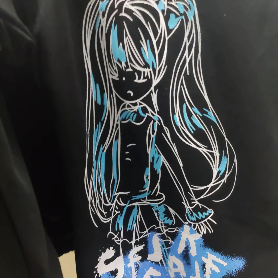 Anime girl graphic design in blue on a black t-shirt, featuring long hair and a stylish pose.