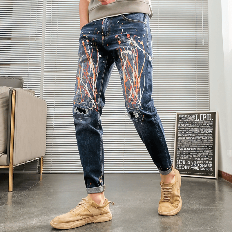 Trendy men's skinny graffiti ripped jeans showcasing an alternative style with colorful splatter design.