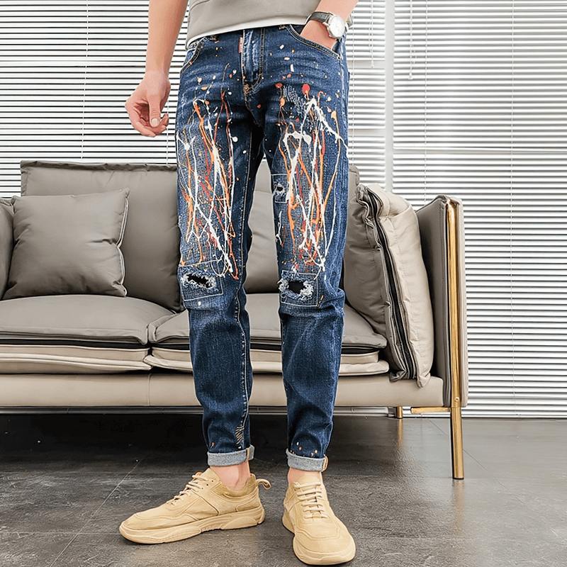 Men's skinny graffiti ripped jeans in an alternative style, featuring a unique design and paired with stylish footwear.