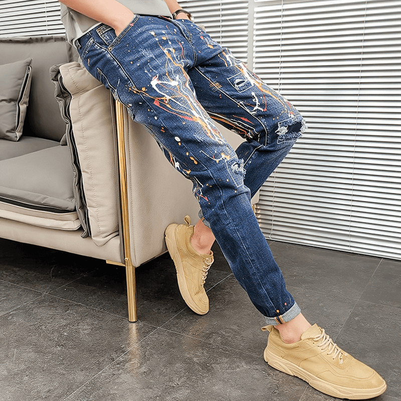 Skinny men's graffiti ripped jeans with elastic trousers style, showcasing trendy design in an alternative fashion look.