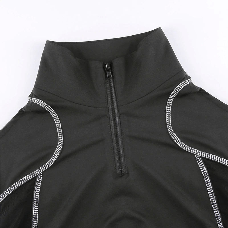 Close-up of a black athletic top with a zip collar and contrast stitching for stylish activewear.