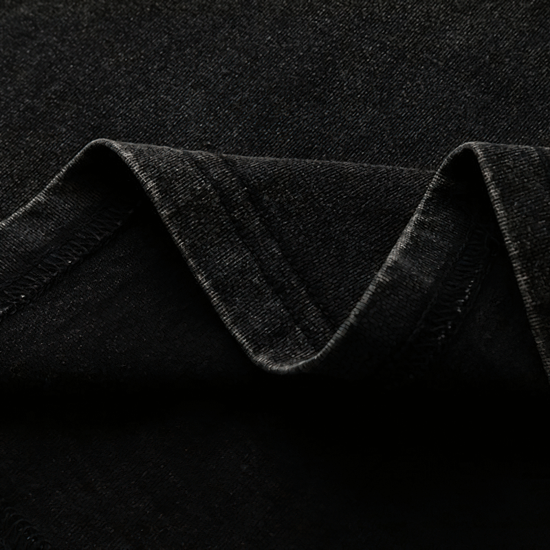 Close-up of soft black fabric showing the texture and wrinkles of a grunge-style cotton tank top.