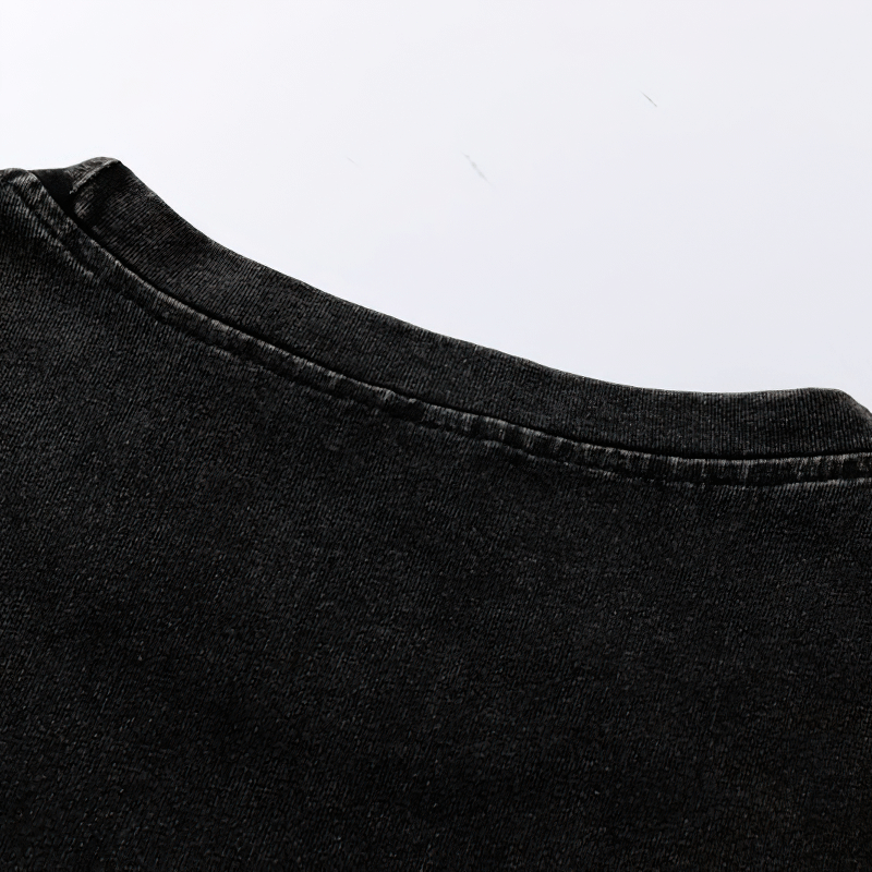 Close-up of the neckline of a black grunge style cotton tank top with quality stitching.