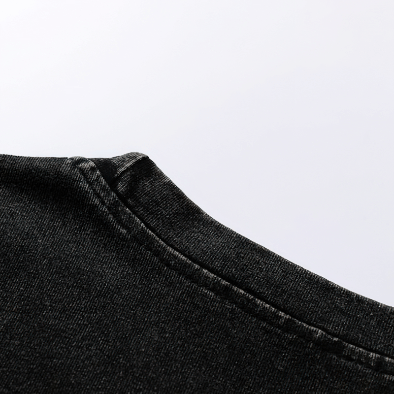 Close-up of the neckline of a grunge-style black cotton tank top showcasing soft fabric and stitching details.