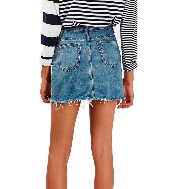 Back view of a grunge style high waist denim mini skirt with pockets, paired with a striped top.