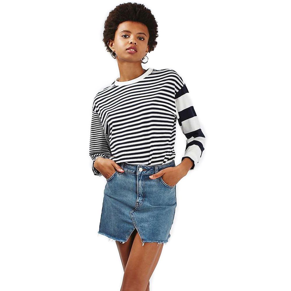 Model showcasing a grunge style high waist denim mini skirt paired with a striped long-sleeve top.