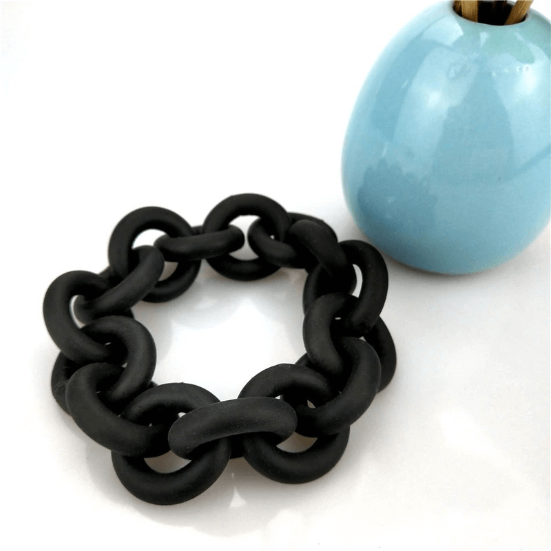 Handmade black rubber bangle for women, perfect punk fashion accessory, paired with a stylish blue vase.