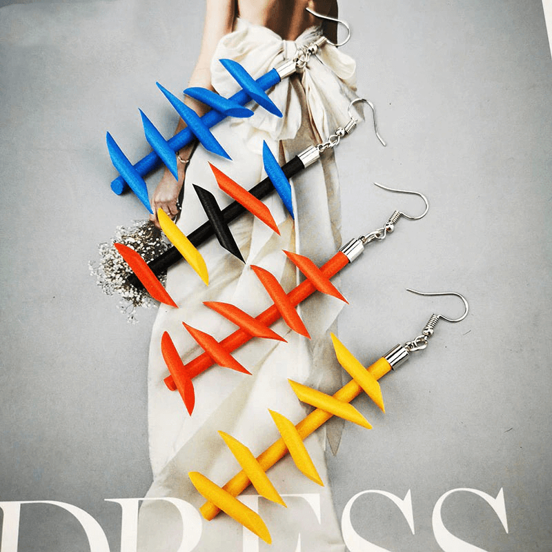 Colorful handmade rubber long earrings for women in gothic style, featuring blue, red, yellow, and black designs on a model.