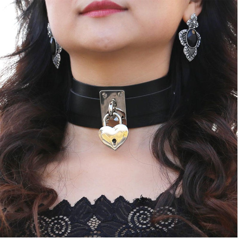 Close-up of a woman wearing a gothic heart choker locket necklace with elegant earrings, perfect for rock style outfits.